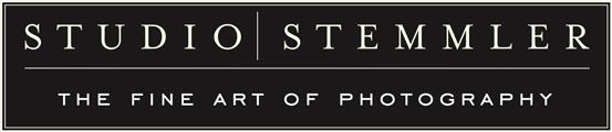 Studio Stemmler Logo: schwarzer Hintergrund mit wei&szlig;er Schrift, oben &bdquo;STUDIO | STEMMLER&ldquo;, unten &bdquo;THE FINE ART OF PHOTOGRAPHY&ldquo;.