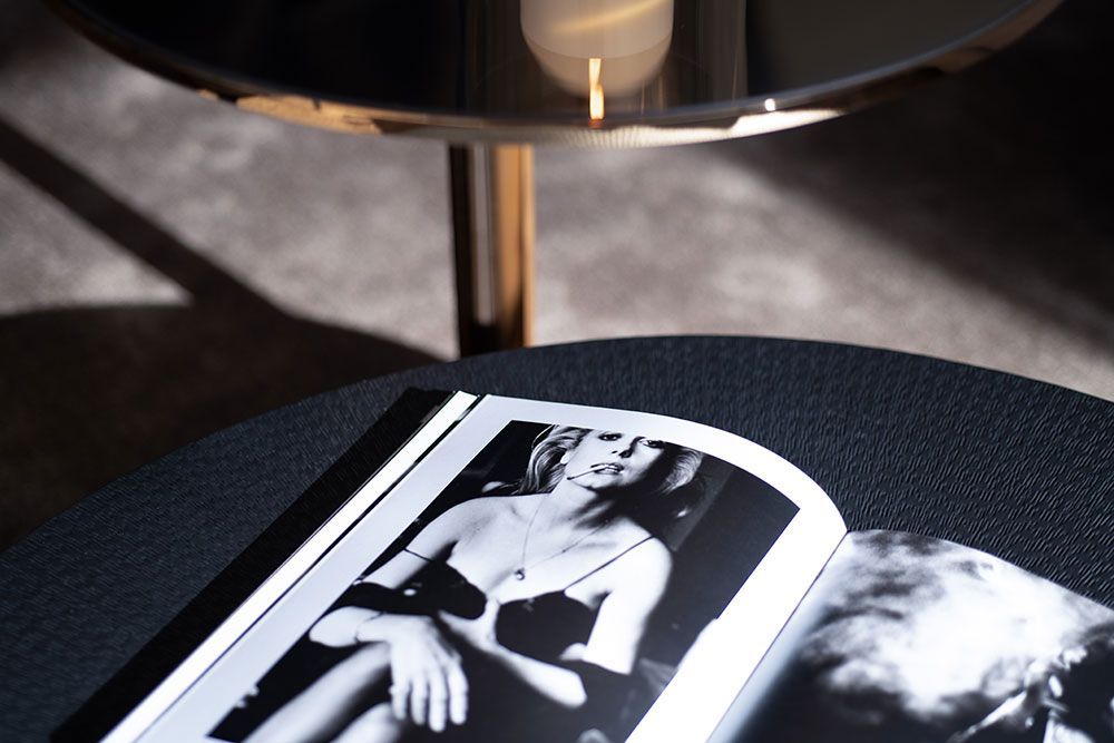 Zeitschrift mit Schwarzweißfoto auf einem Tisch unter einer Lampe.