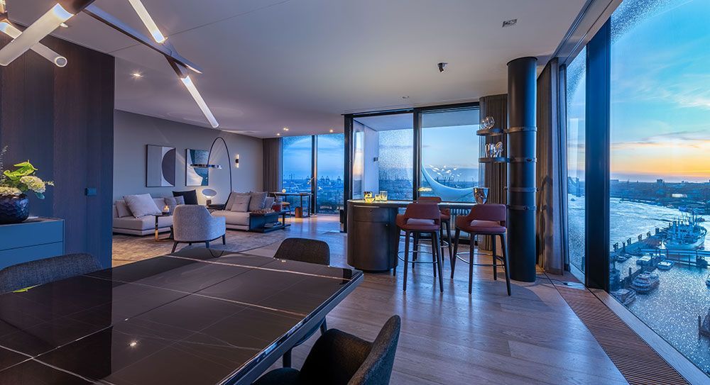 Luxuriöses, modernes Interieur mit Stadtblick, Barhockern und Esstisch.