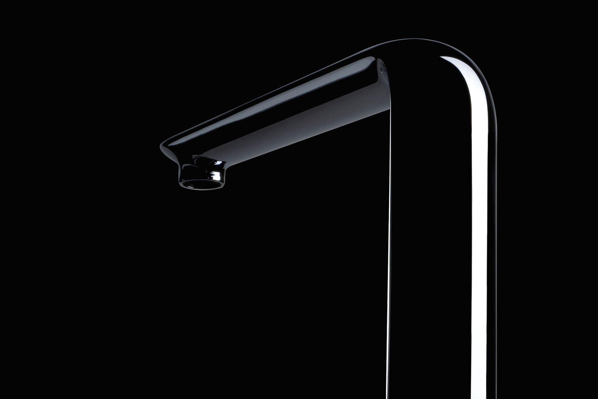 Glänzender, schwarzer Wasserhahn vor schwarzem Hintergrund.