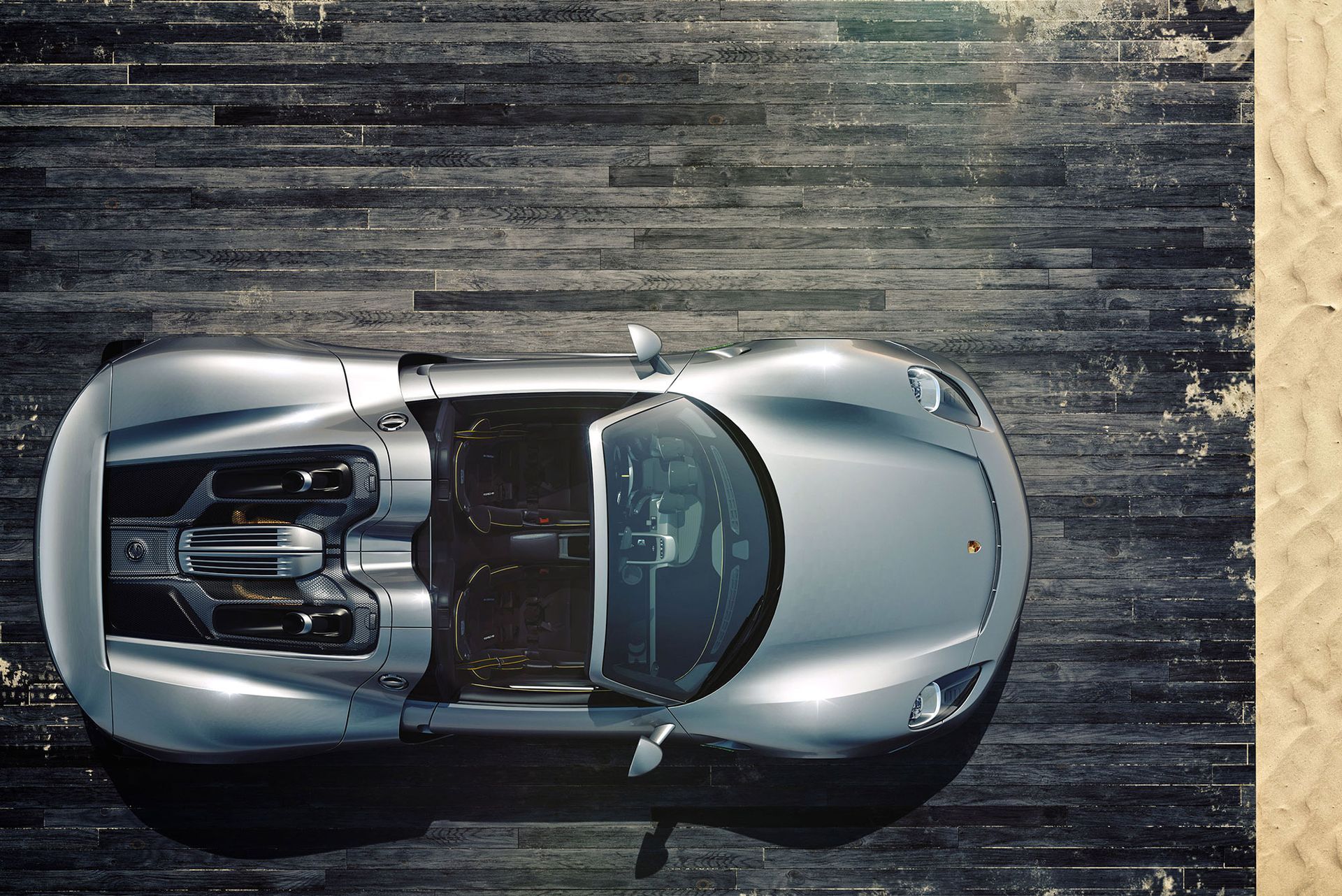 Silberner Sportwagen, geparkt auf Holzplanken, Draufsicht.