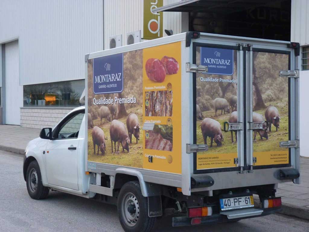 Um caminhão branco com uma foto de porcos na lateral