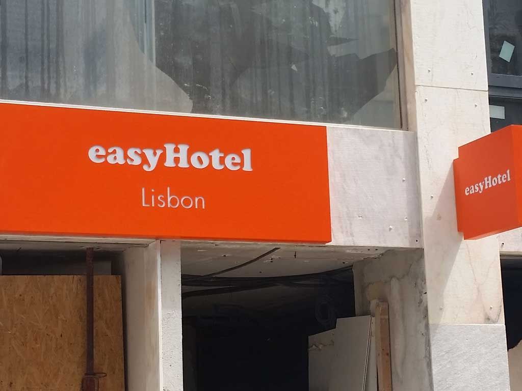 Uma placa laranja que diz easyhotel lisbon