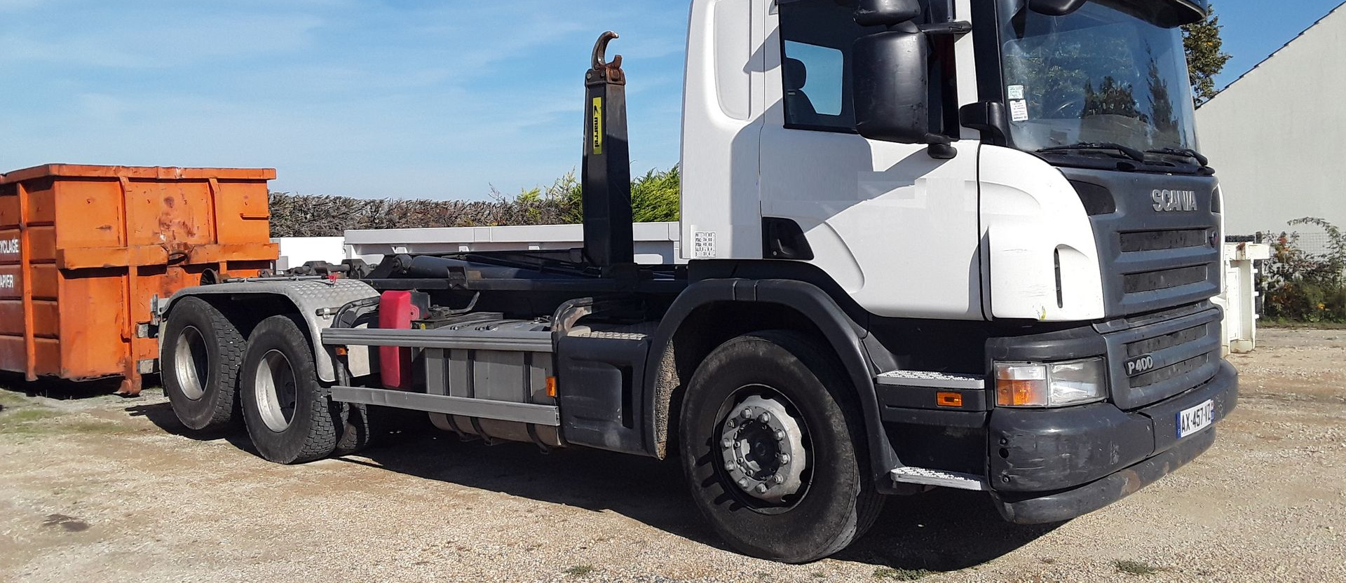 Camion blanc avec benne orange.