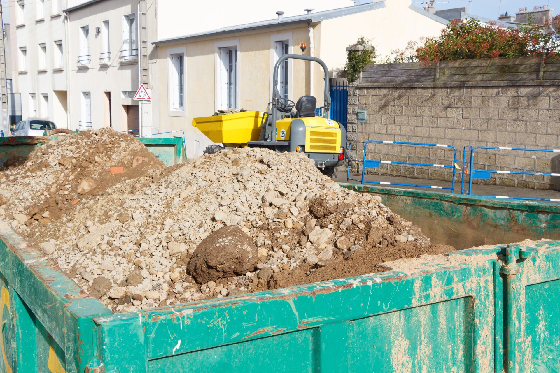 De la terre dans une benne verte.