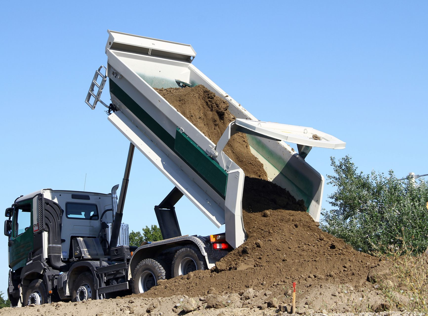 Un camion-benne décharge de la terre.