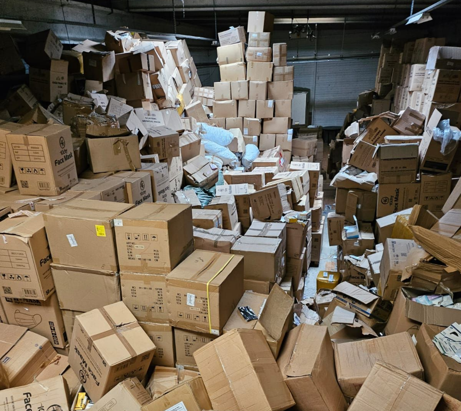 Un entrepôt encombré, rempli de piles de cartons et de débris.