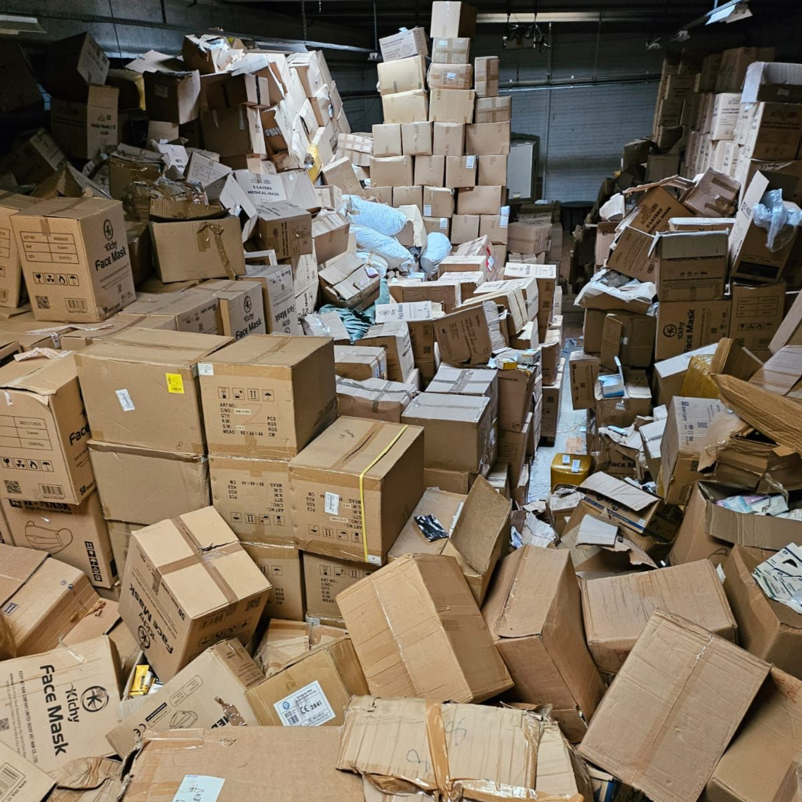 L'intérieur d'un entrepôt rempli de cartons empilés.