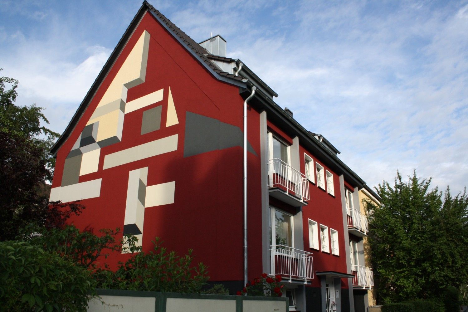 Ein rotes Gebäude mit einem geometrischen Muster an der Seite