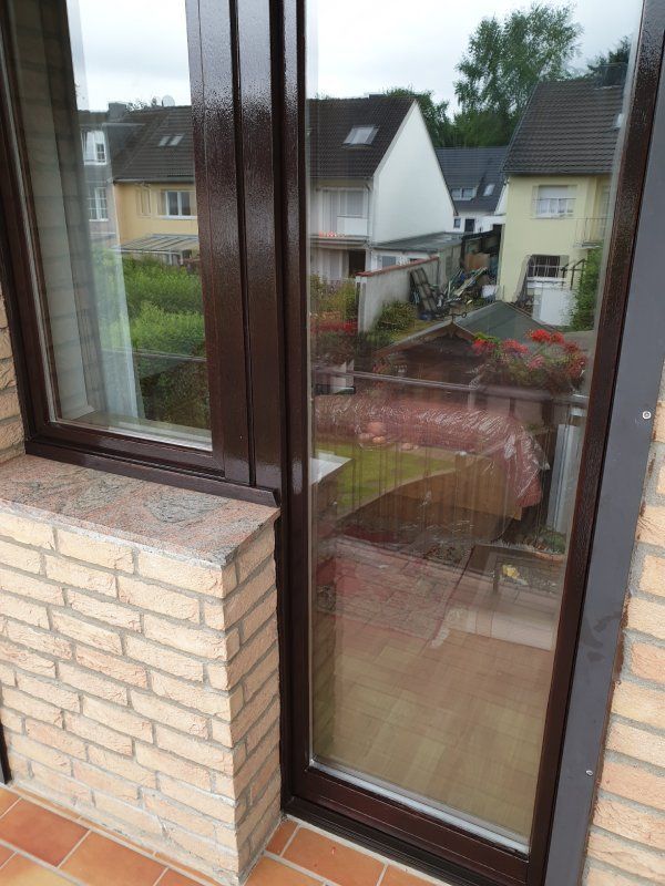 Ein Backsteingebäude mit einer Glasschiebetür, die auf einen Balkon führt.