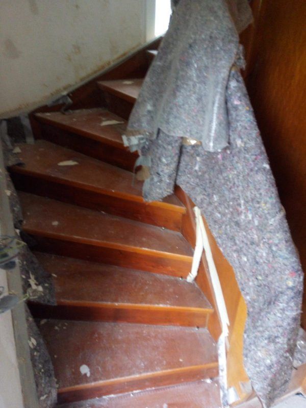 Eine Holztreppe mit einer Decke auf dem Geländer.