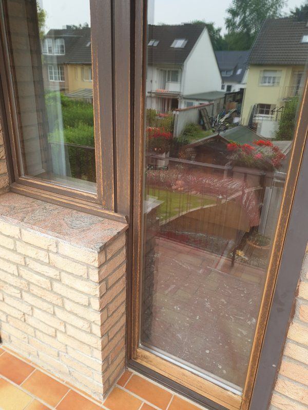 Ein Backsteingebäude mit einer Glasschiebetür und einem Fenster.