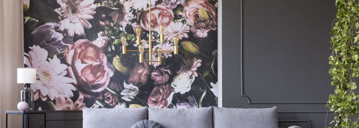 Ein Wohnzimmer mit einer Couch und einer großen Blumentapete an der Wand.