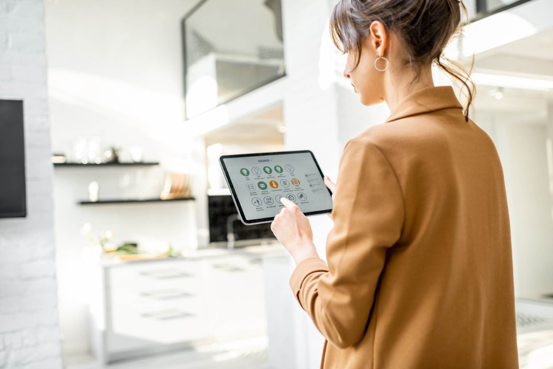 Eine Frau steuert die Technik in einem Wohnzimmer mit einem Tablet