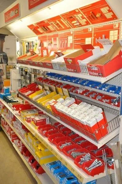 Regal mit einer Auswahl an Werkzeugen, Befestigungsmaterial und roten Sortierboxen.