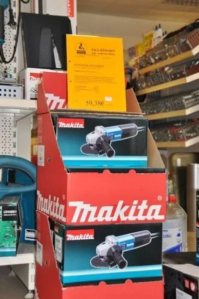 Regal in einem Baumarkt mit verschiedenem Werkzeug und einer gelben Infotafel im Vordergrund