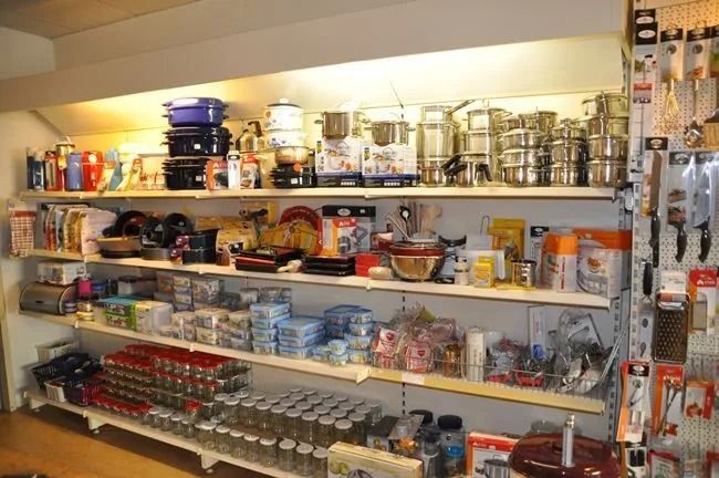 Regale voller Küchenutensilien, Töpfe, Pfannen und Haushaltswaren