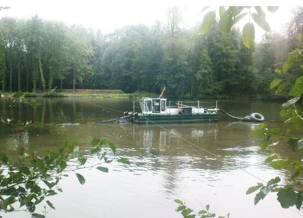 Petit bateau qui nettoie un plan d'eau