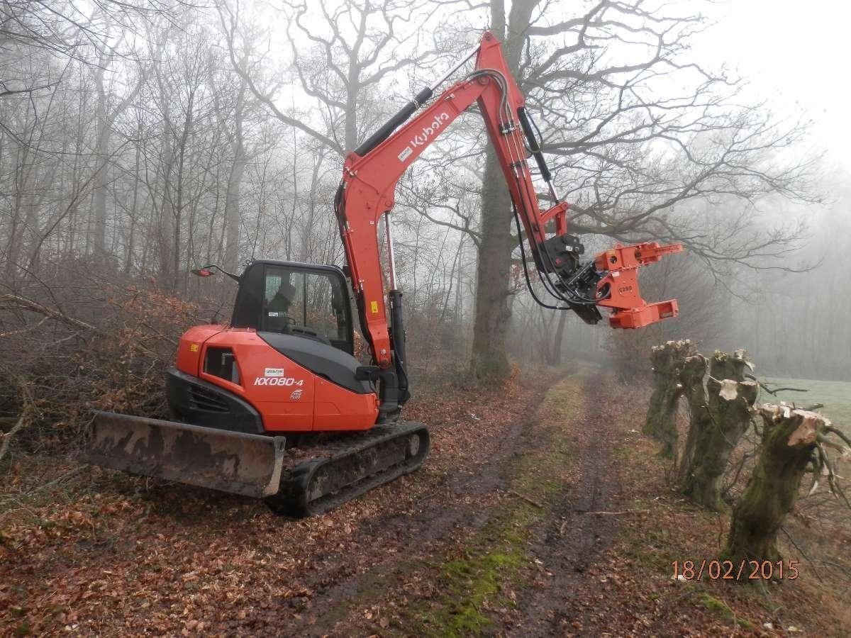 Entretien d'arbres avec une tractopelle rouge