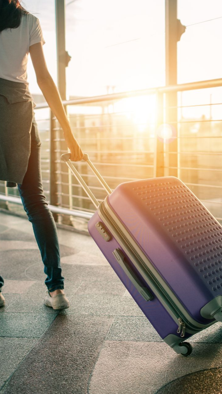 Une personne tirant une valise dans un aéroport.