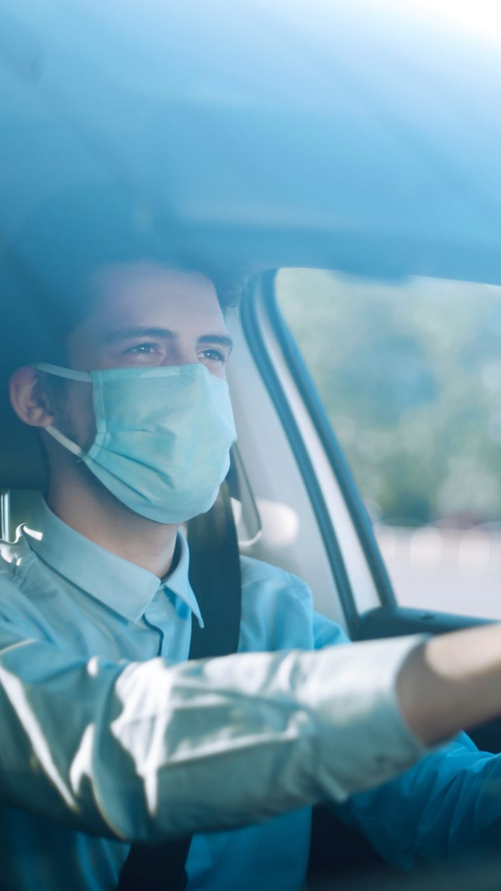 Une personne conduit une voiture, les mains sur le volant.