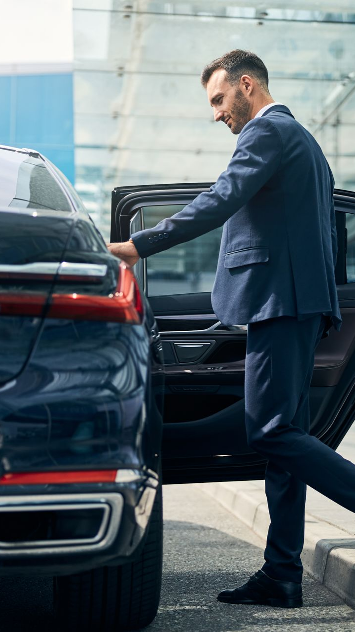 Un homme rentre dans un voiture. 