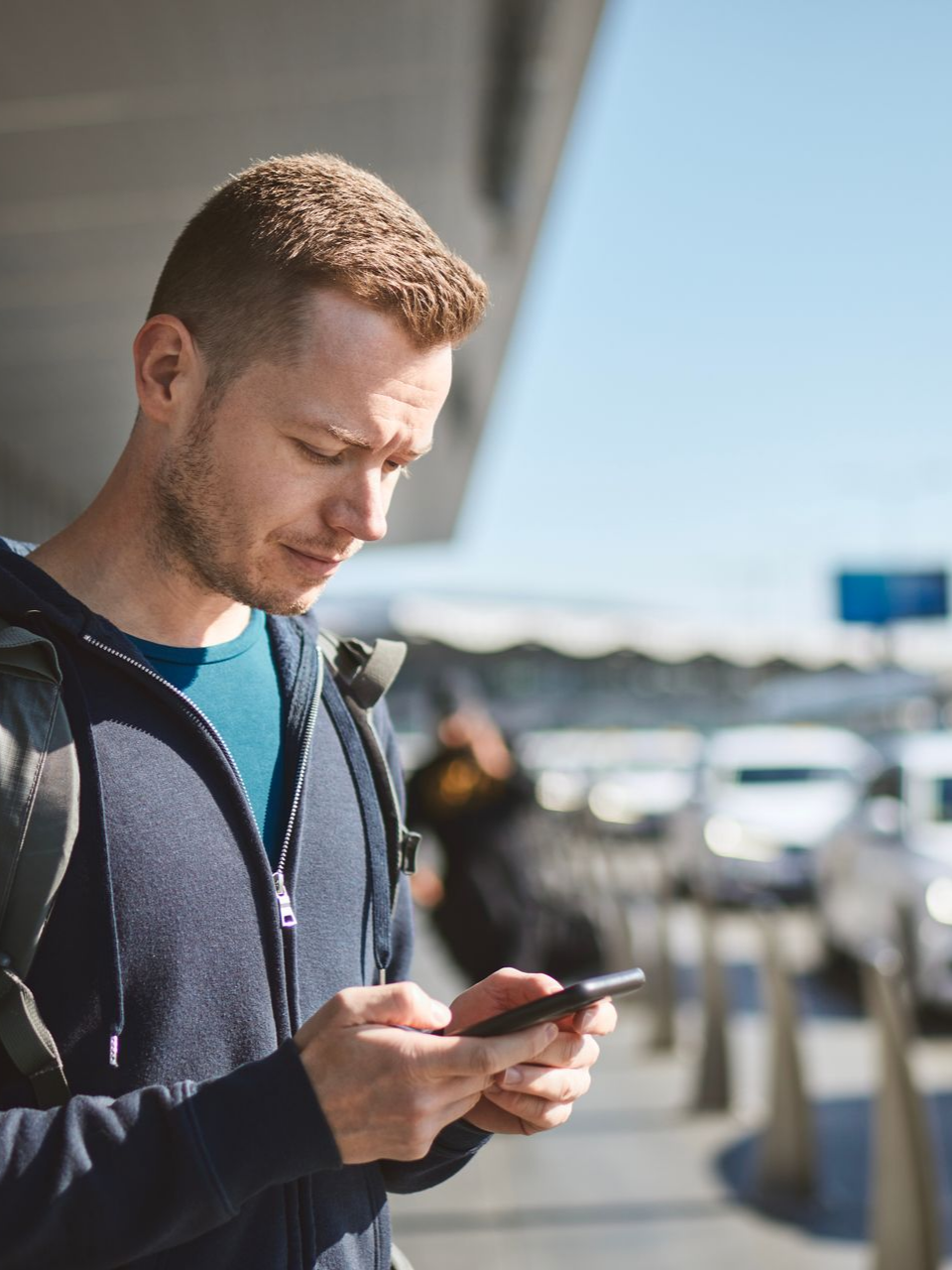 Homme regardant son téléphone à l'extérieur.