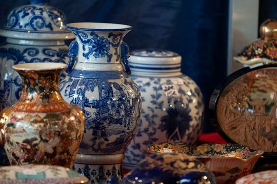 Vases et bols décoratifs en céramique bleue et blanche disposés ensemble sur une étagère.