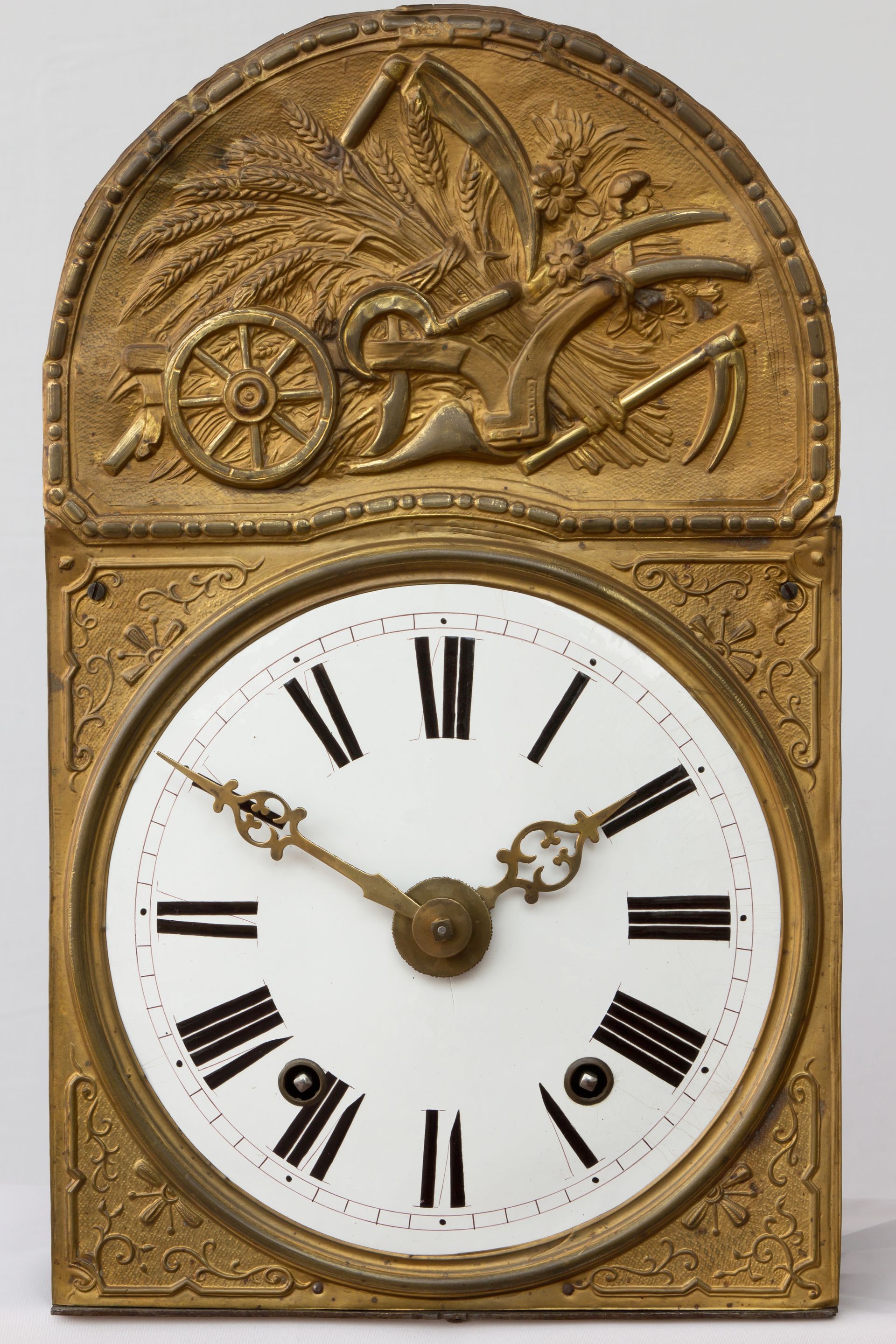 Pendule de cheminée ancienne en laiton avec cadran blanc et chiffres romains, surmontée d'une scène représentant un cheval et une calèche.