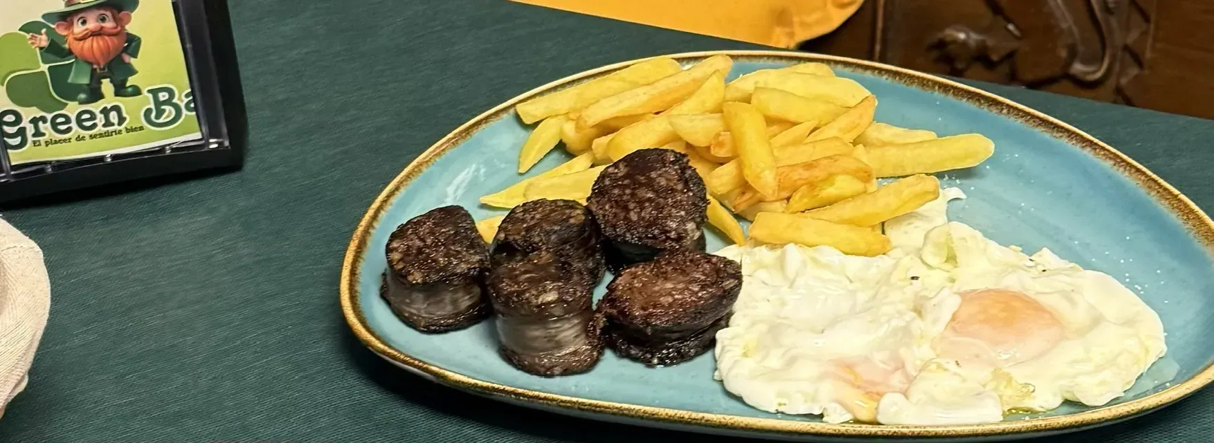 Plato de morcilla, patatas fritas y huevos fritos.
