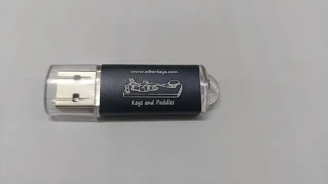 Una unidad flash USB negra está sobre una mesa.