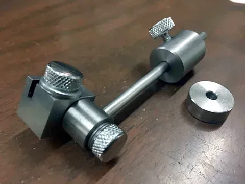 Un objeto de metal está sobre una mesa de madera.