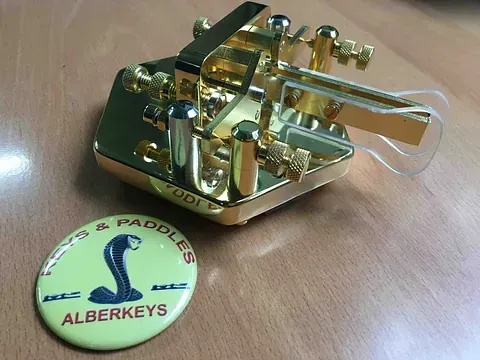 Un objeto dorado con un botón amarillo que dice alberkeys