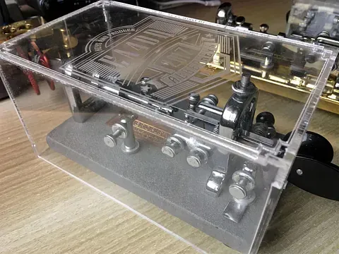 Un primer plano de un dispositivo mecánico en una caja transparente sobre una mesa.