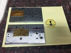 Dos placas de metal están colocadas encima de un trozo de papel sobre una mesa.