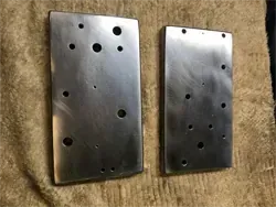 Dos placas de metal con agujeros están colocadas sobre una toalla.
