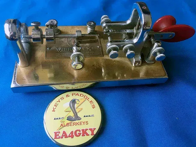 Una insignia de teclas y paletas ea4gky se encuentra sobre una tela azul