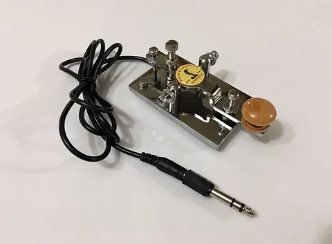 Una llave con un cordón unido a ella reposa sobre una superficie blanca.