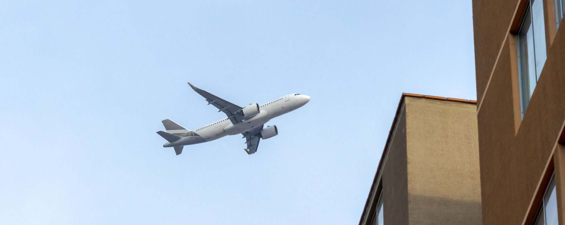 Un avion vole au dessus de logements