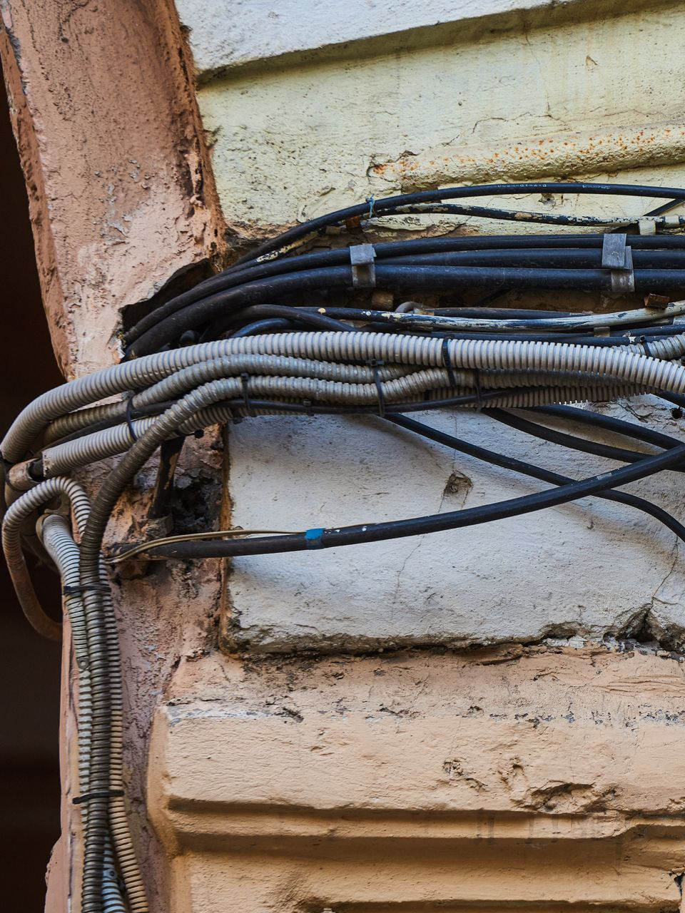 Fils électriques dans des conduits en plastique fixés à l'extérieur d'un bâtiment