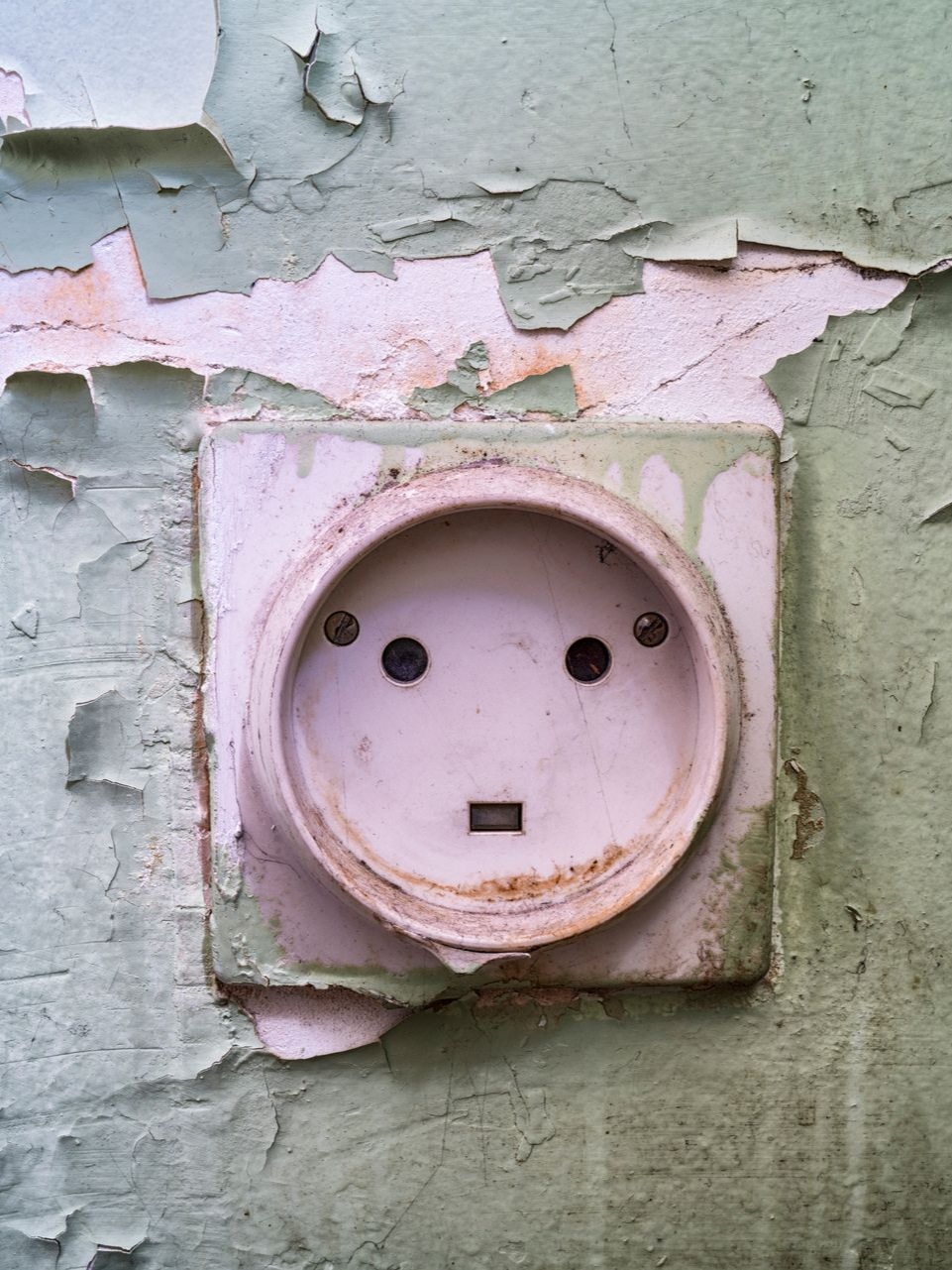 Une prise électrique usée par les intempéries sur un mur