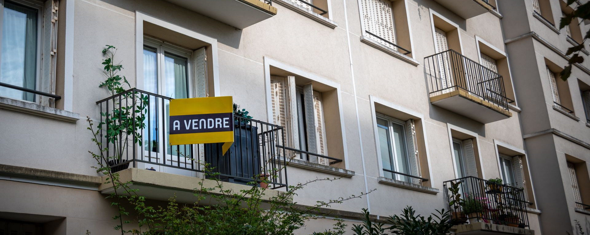 Immeuble avec un panneau À vendre sur un balcon