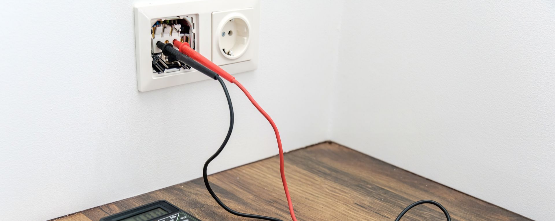 Prise électrique testée avec des sondes multimètre