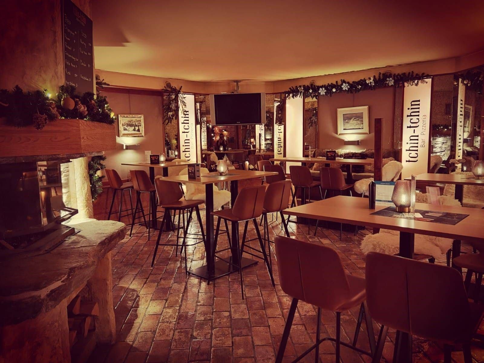 Un restaurant avec des tables et des chaises et une cheminée.