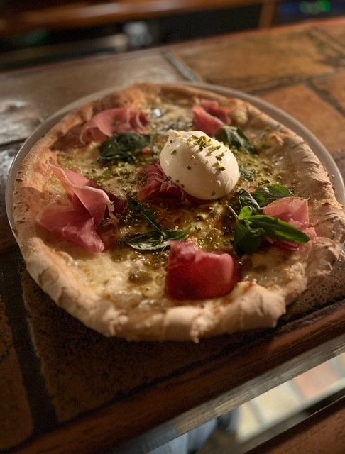 Une pizza au jambon et au fromage dans une assiette sur une table