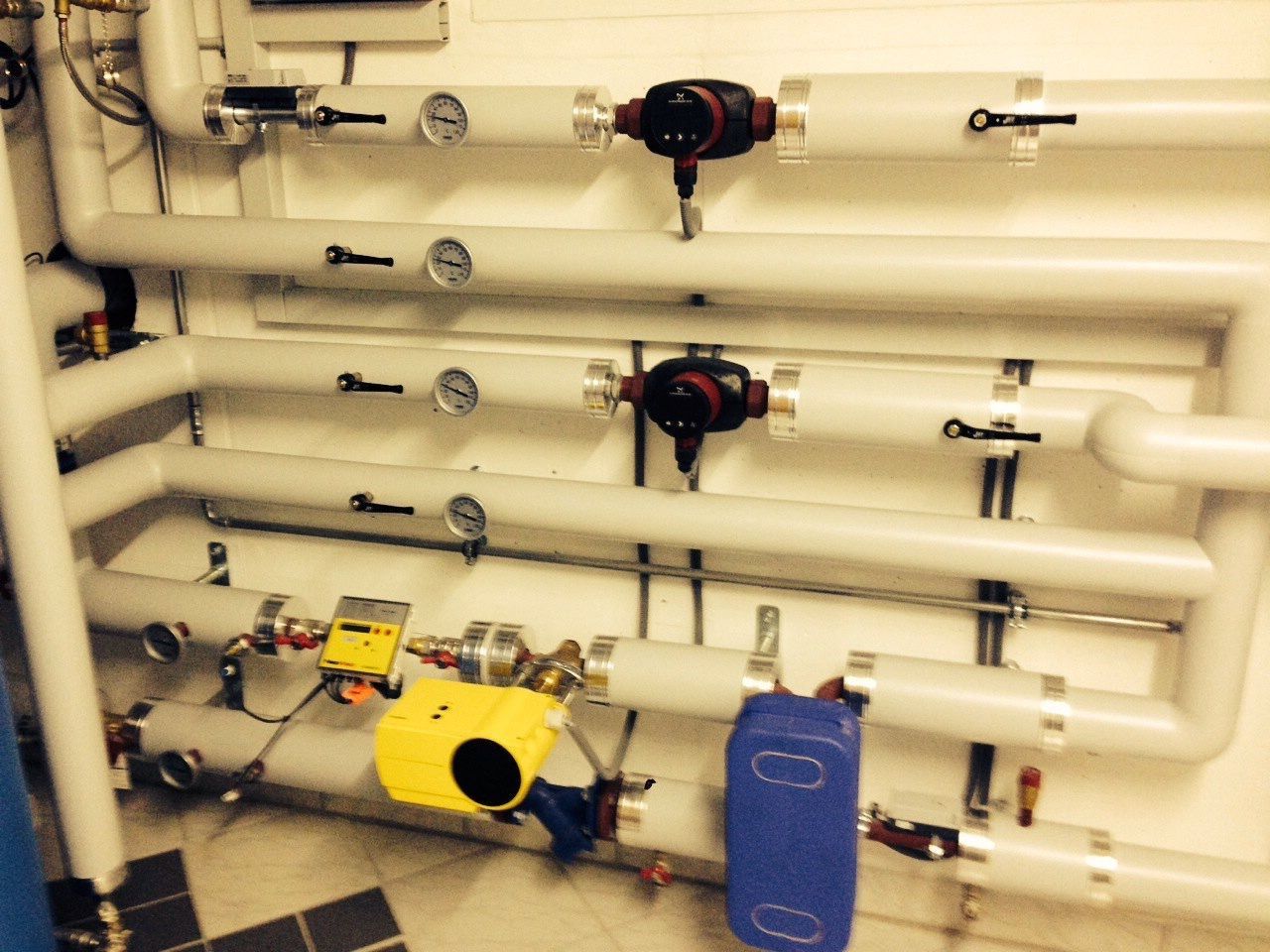 Eine Person arbeitet an einem Warmwasserbereiter und verbindet mit den Händen ein Rohr.