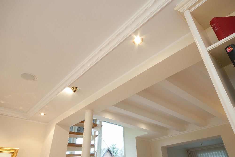 Ein Wohnzimmer mit einer Treppe und einer weißen Decke