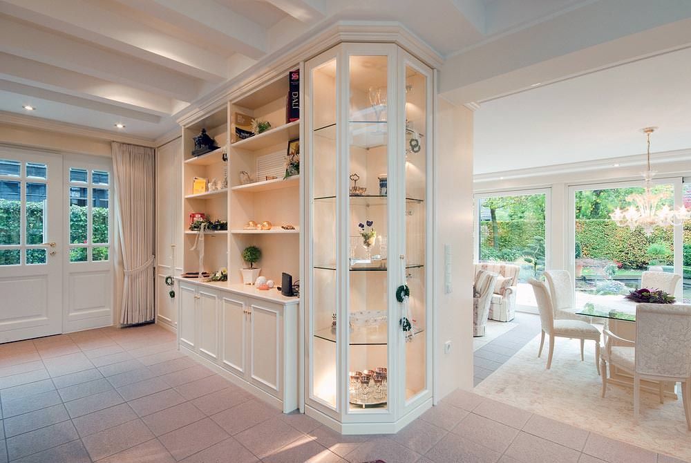 Ein Wohnzimmer mit Esszimmer und einem Eckschrank mit Glastüren.