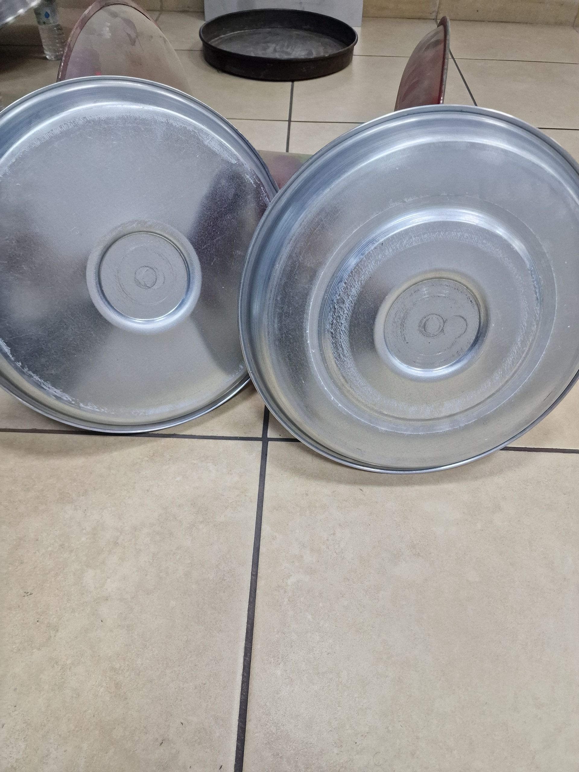 Δύο στρογγυλοί μεταλλικοί δίσκοι σε πλακόστρωτο δάπεδο. Ο ένας δίσκος είναι ελαφρώς αριστερά και ο άλλος δεξιά.