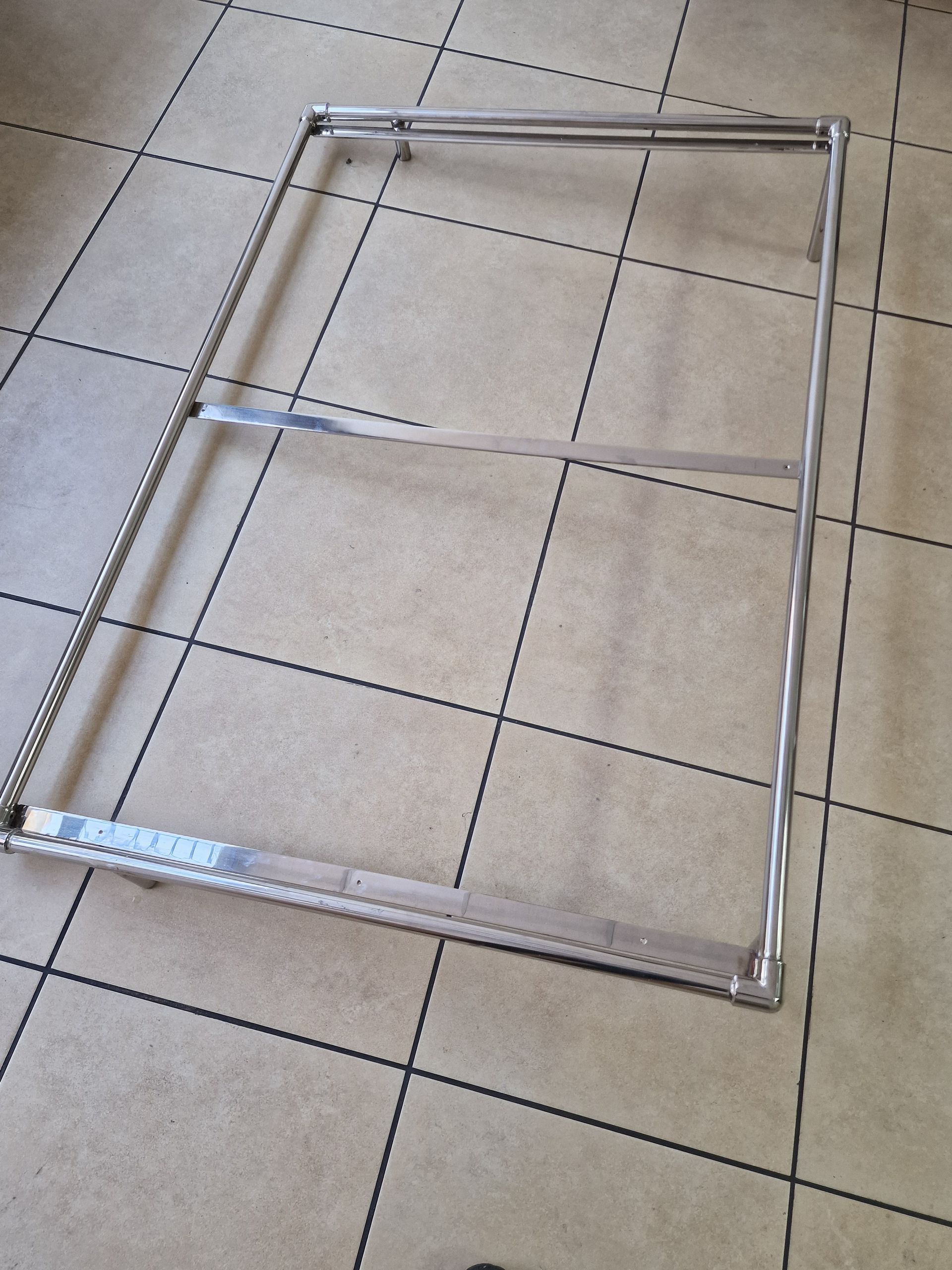 Μεταλλικό ορθογώνιο πλαίσιο σε πλακόστρωτο δάπεδο. Μια οριζόντια ράβδος διχοτομεί το πλαίσιο.